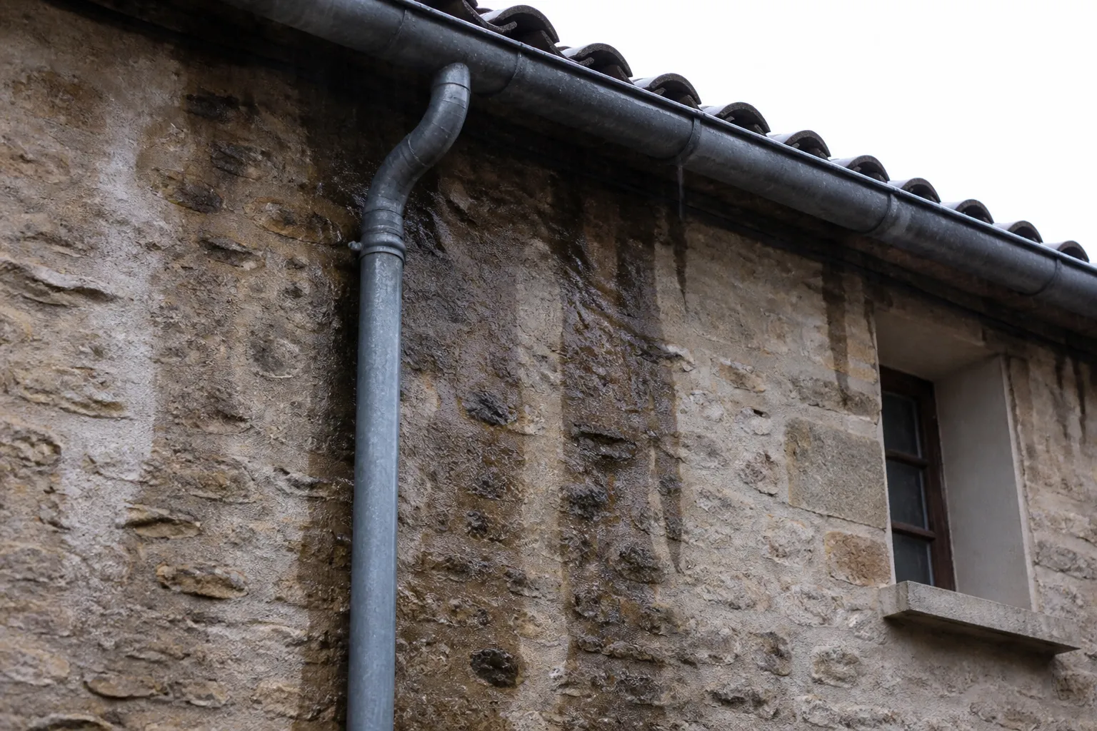 Gouttière et descente d’eau sur une façade