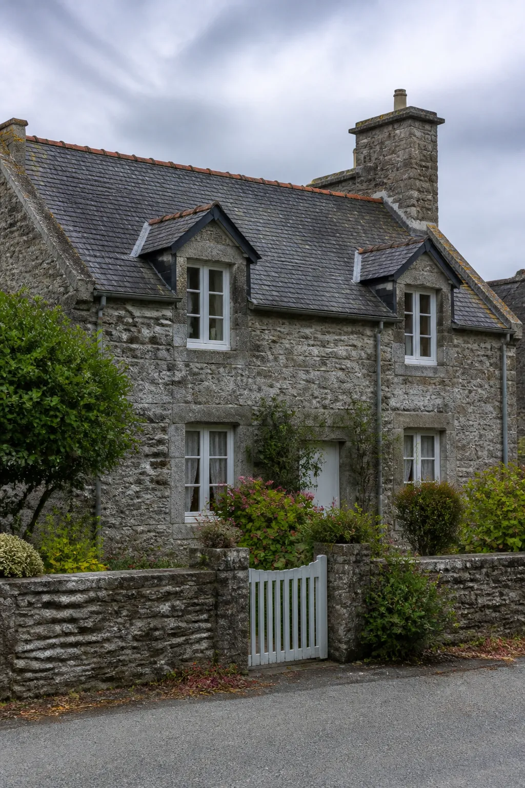 Maison ancienne en pierre avec toit d’ardoise et jardin