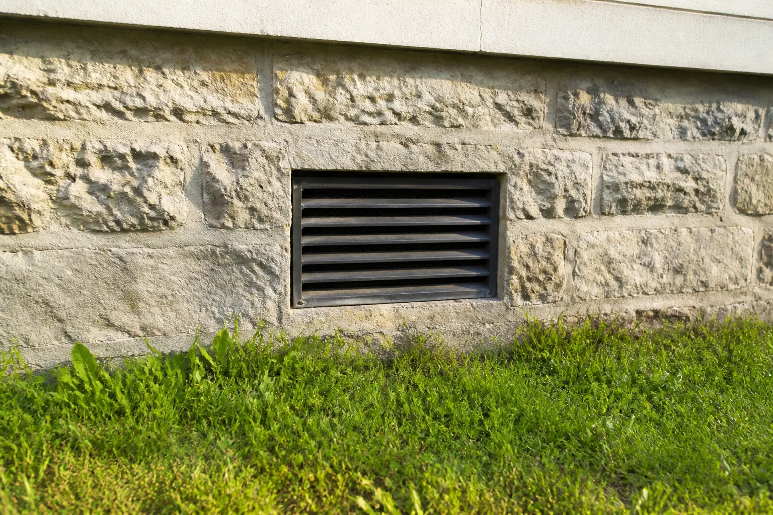 Bouche d’aération basse sur un mur de maison