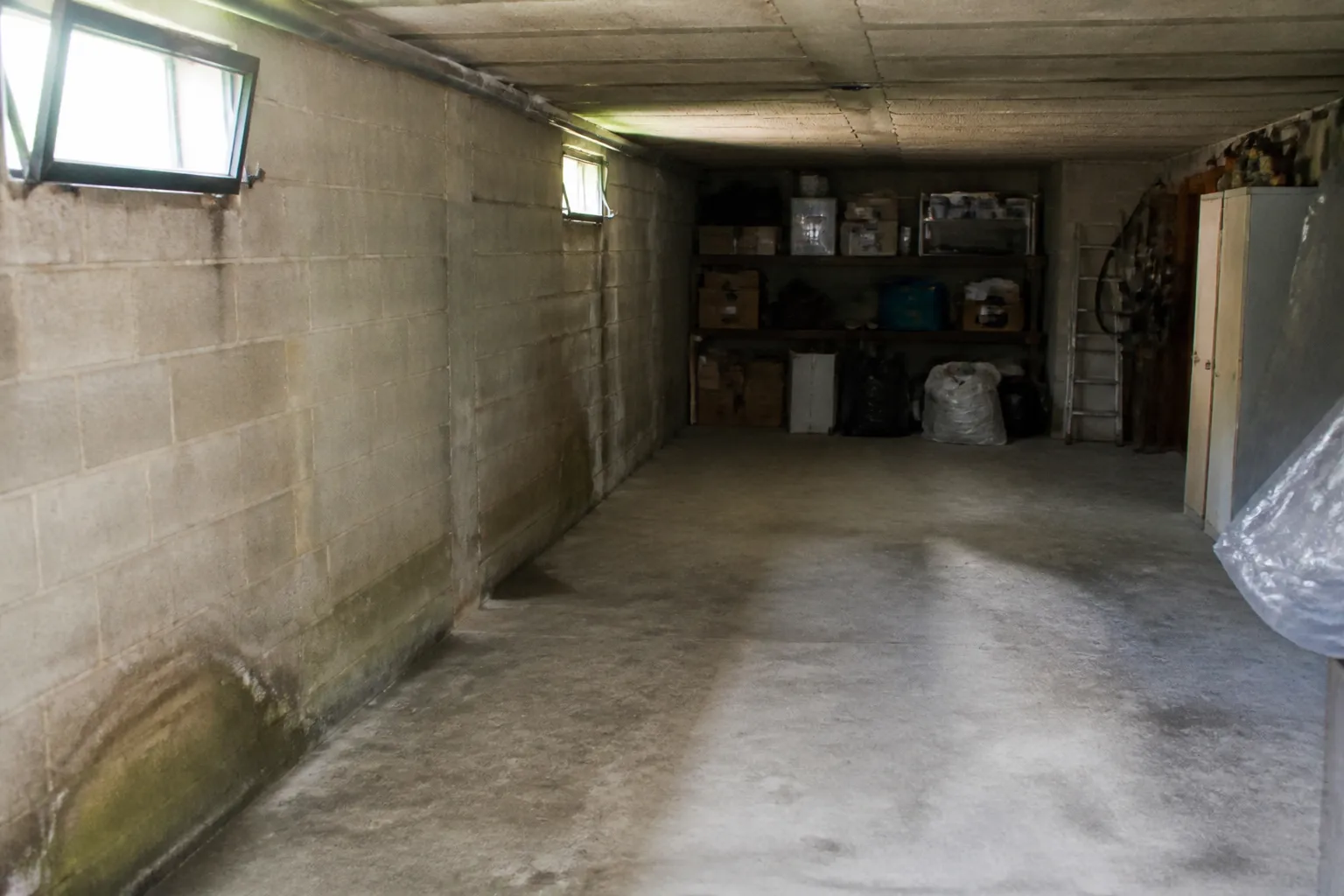 Garage en sous-sol avec traces d’humidité au pied des murs
