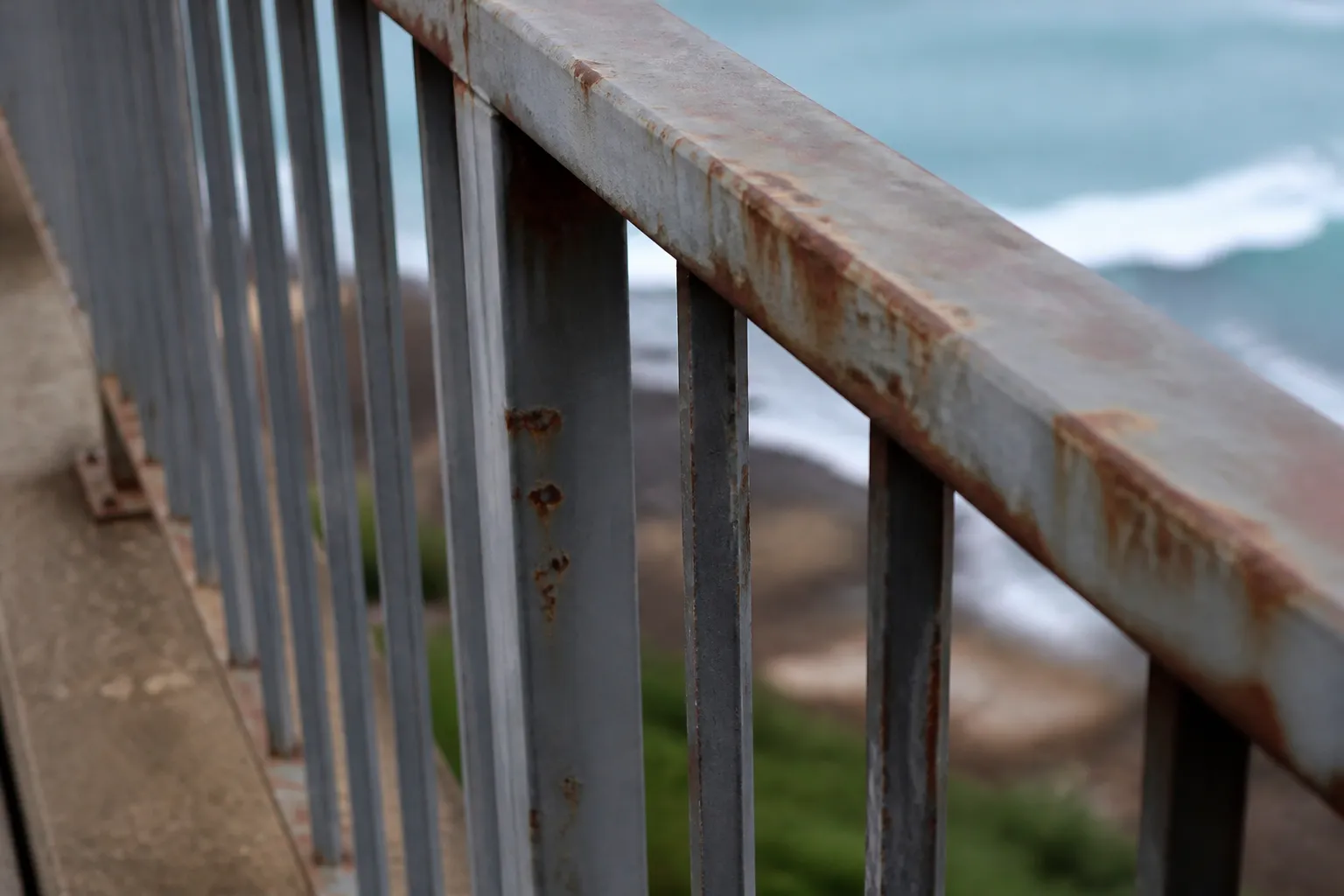 Garde-corps métallique corrodé sur un balcon en bord de mer