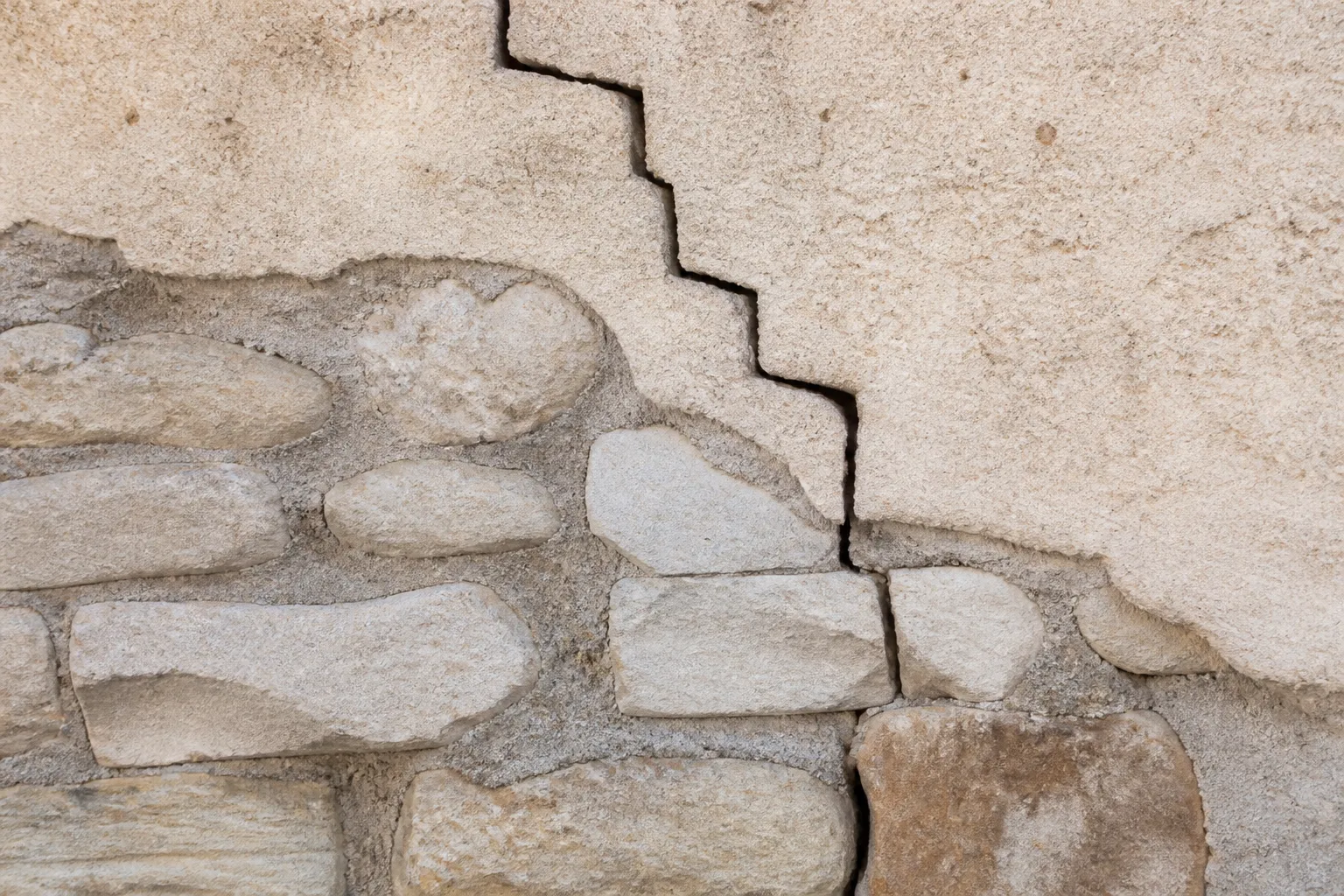 Fissure en escalier relevée sur un mur extérieur en pierre
