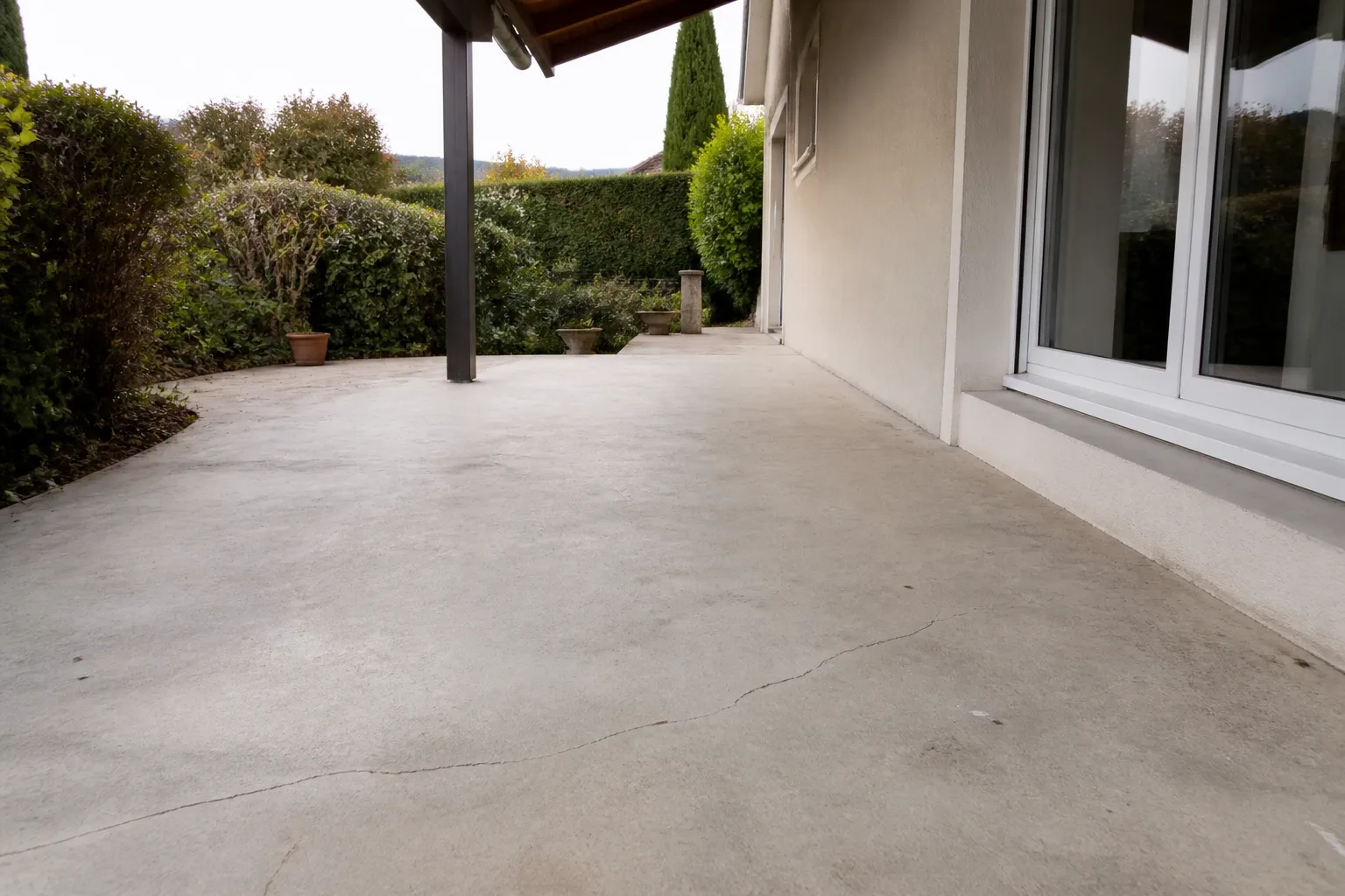Dallage de terrasse fissuré le long d’une maison individuelle