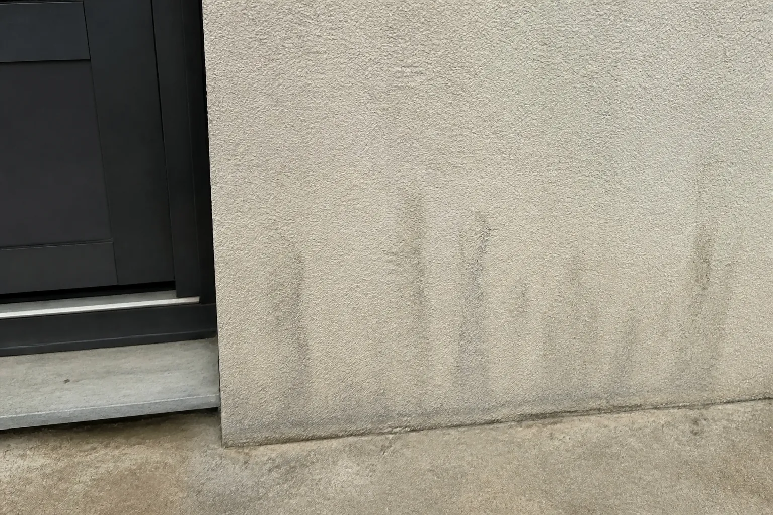 Seuil de porte et bas de mur extérieur après de fortes pluies