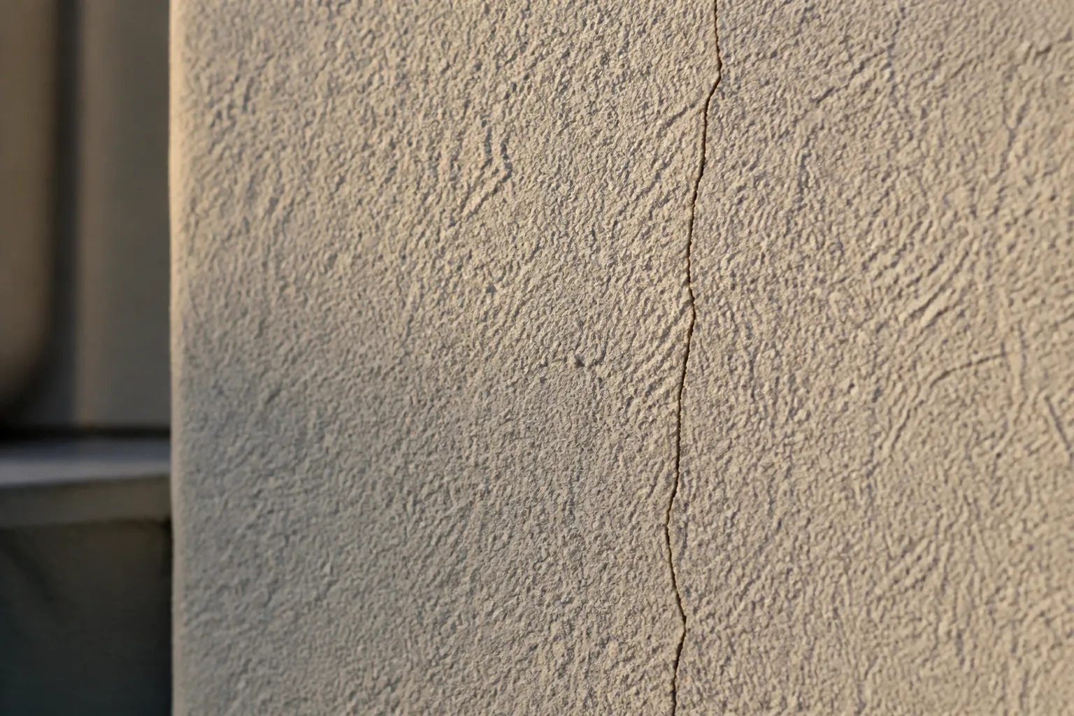 Fissure fine sur un mur extérieur enduit