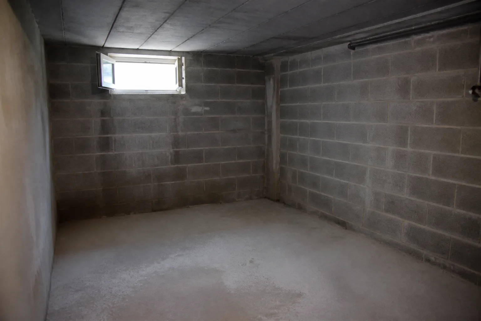 Cave avec murs en parpaings et soupirail