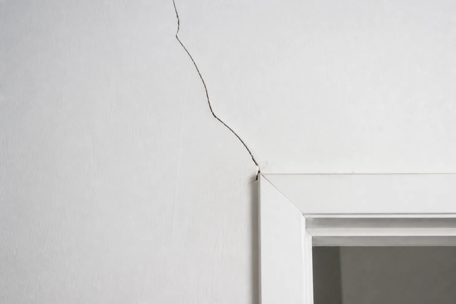 Fissure sur un mur intérieur près d’une porte