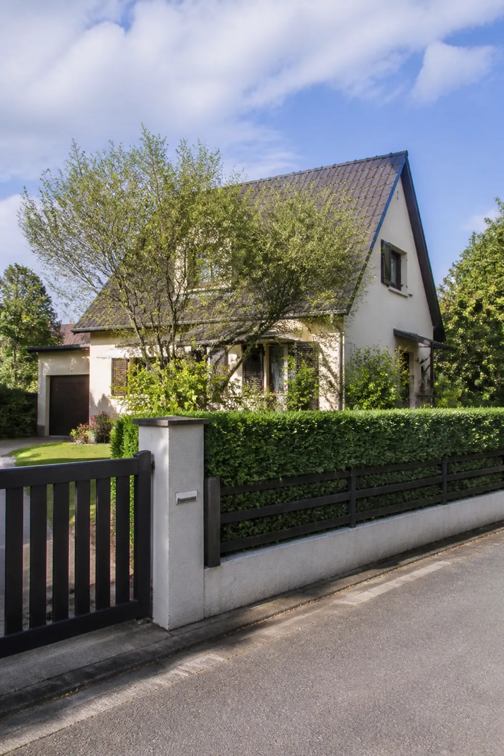 Maison individuelle avec portail et jardin en zone pavillonnaire