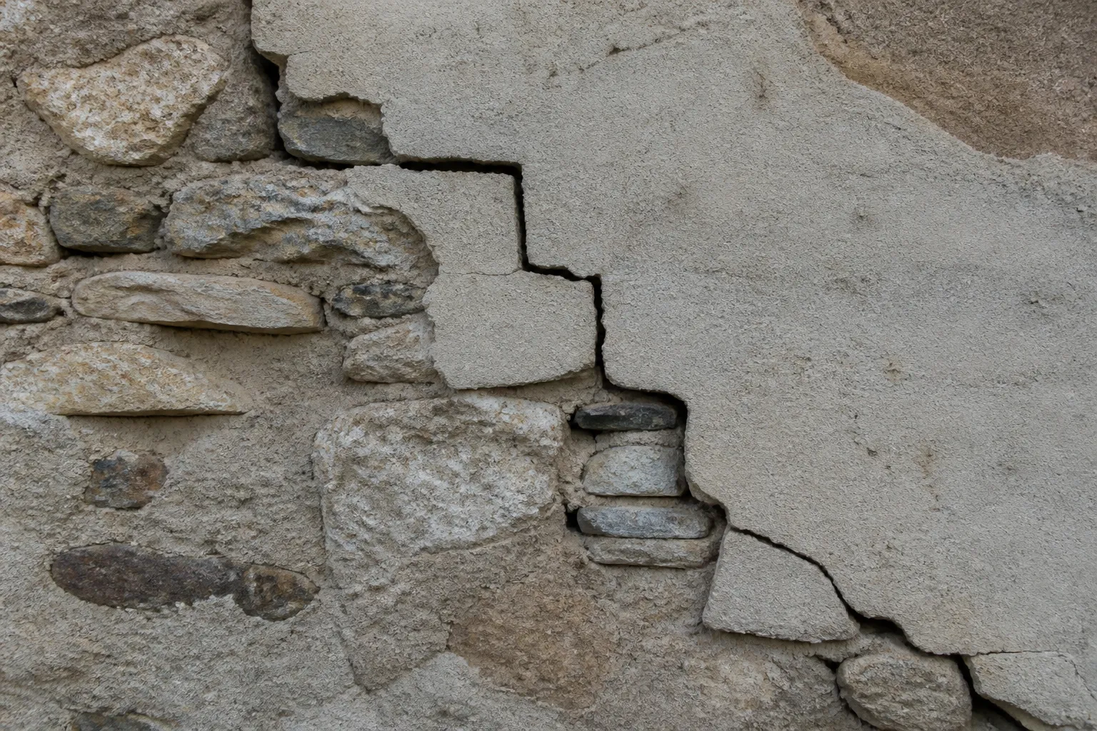 Fissure en escalier sur un mur extérieur en moellons