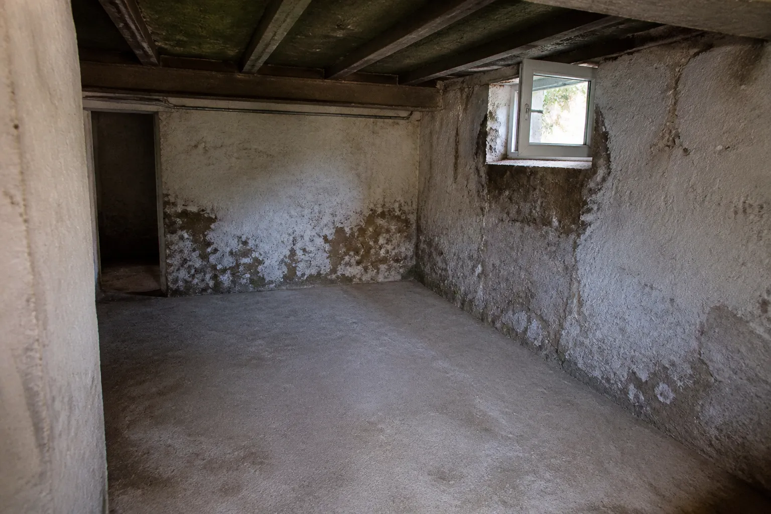 Sous-sol de maison avec traces d’humidité en pied de mur