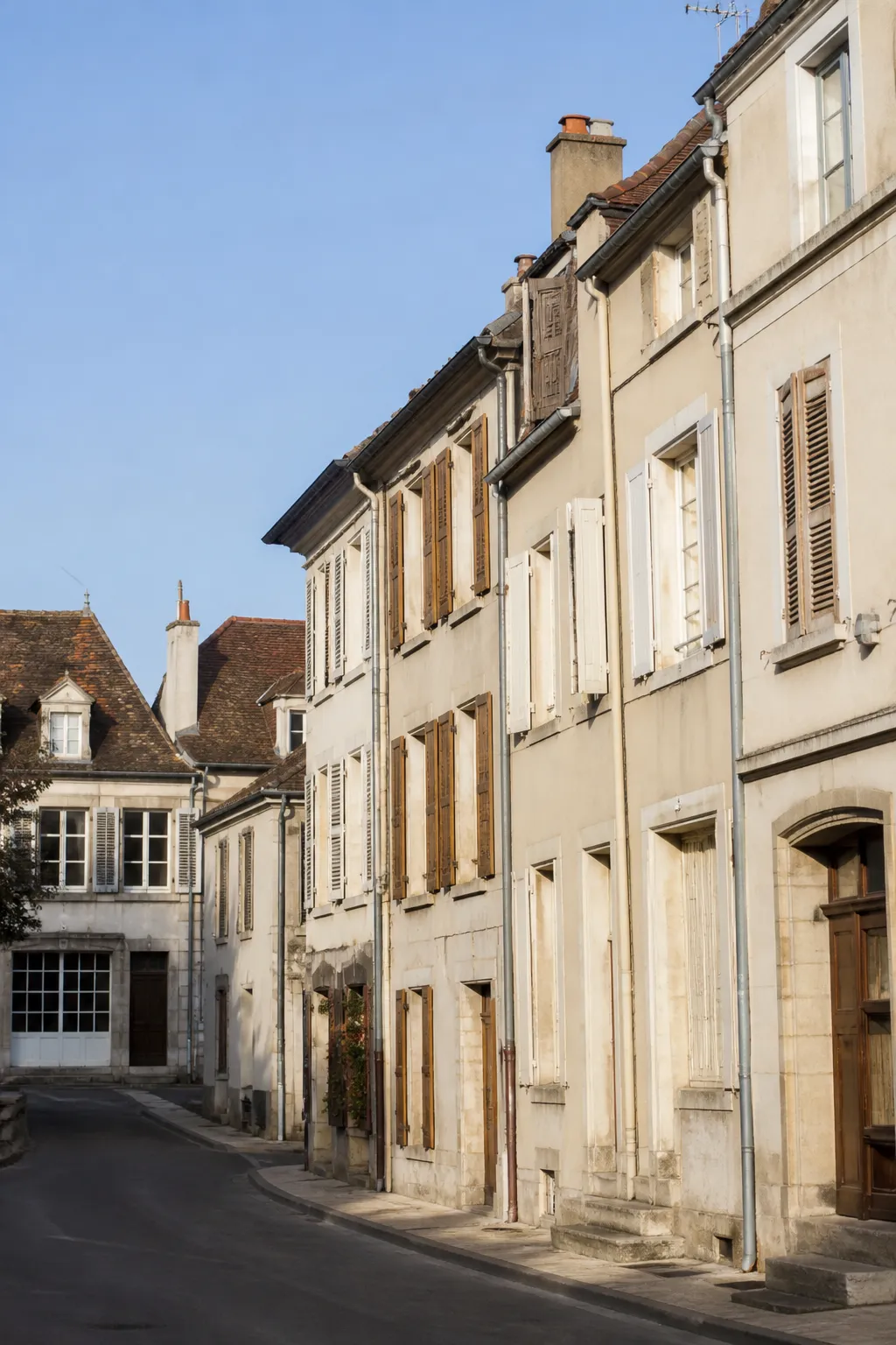 Immeubles anciens à façades enduites dans une rue de centre-ville
