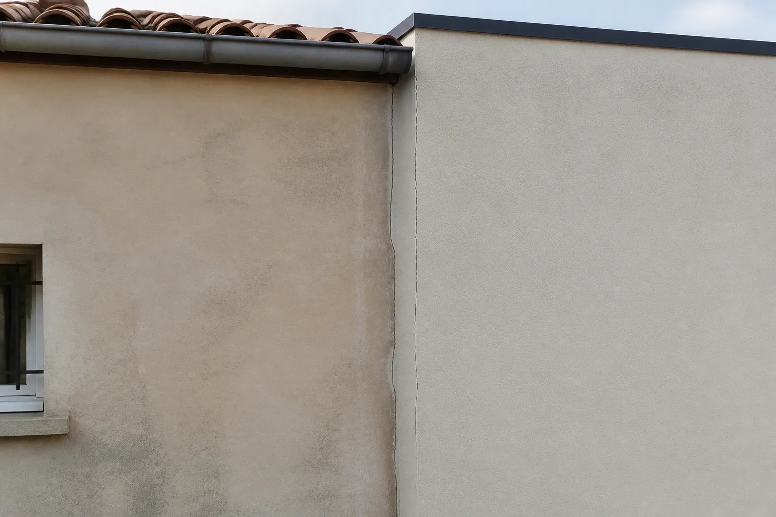 Jonction entre une maison et son extension avec une fissure fine