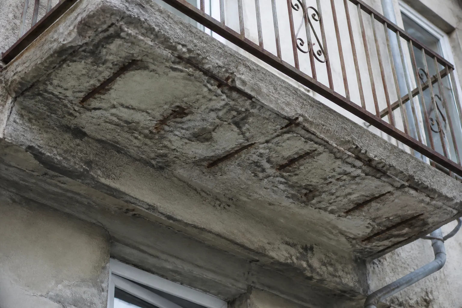 Sous-face de balcon en béton avec éclat et armature visible