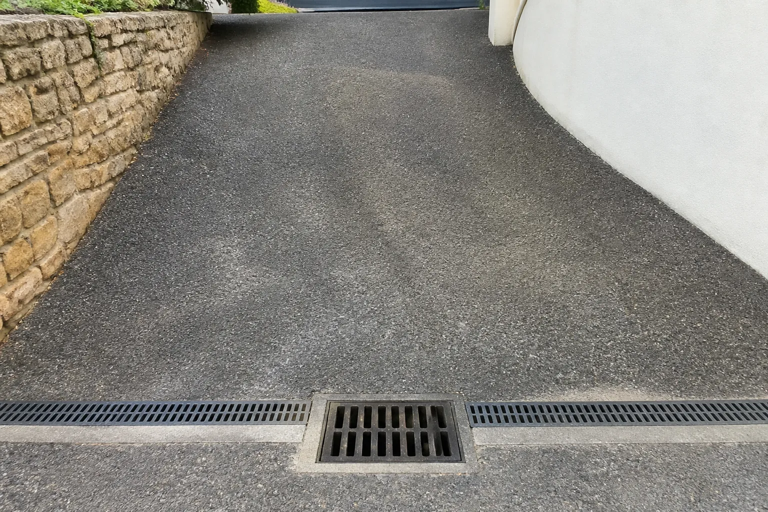 Caniveau et regard d’eaux pluviales en haut d’une allée en pente