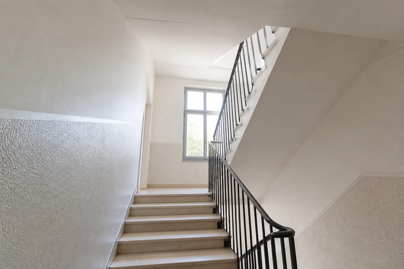 Cage d’escalier d’une copropriété avec fissure fine au plafond