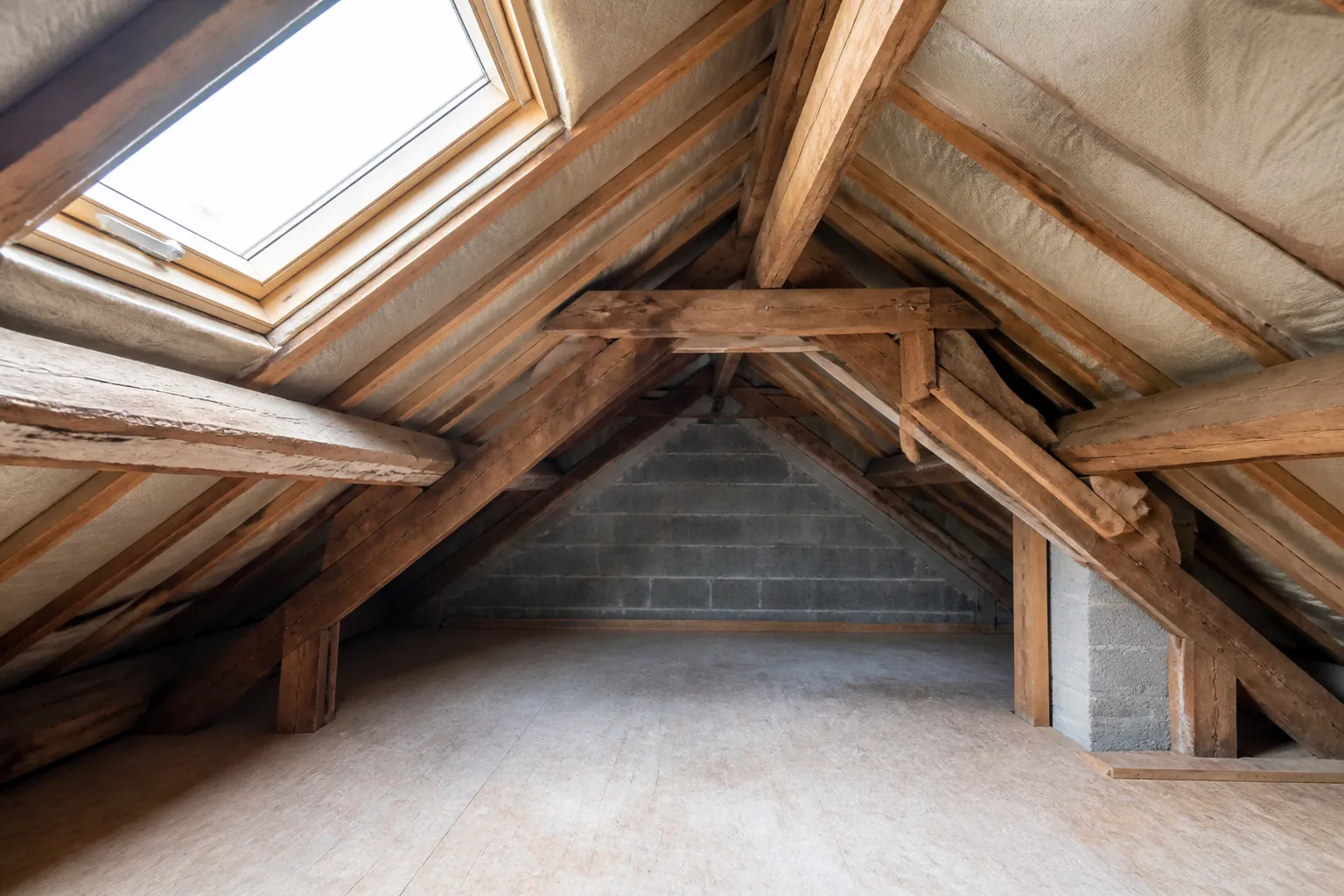 Combles avec charpente en bois et isolant visible
