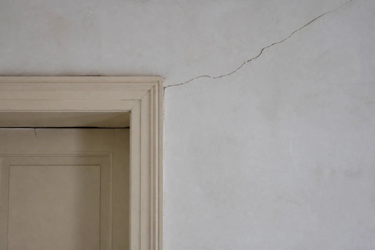 Fissure oblique au-dessus d’une porte dans un appartement ancien