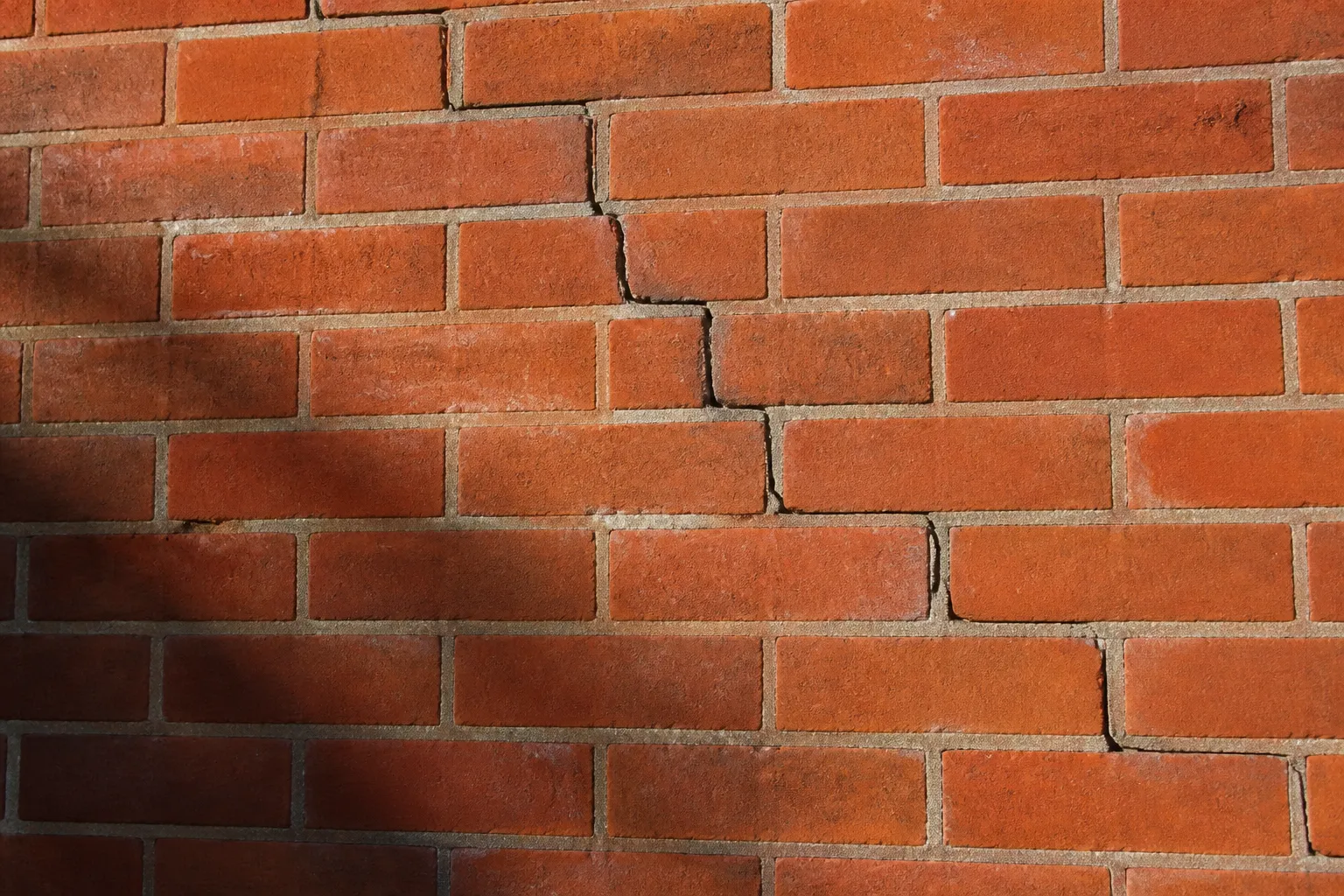 Fissure en escalier sur un mur de brique