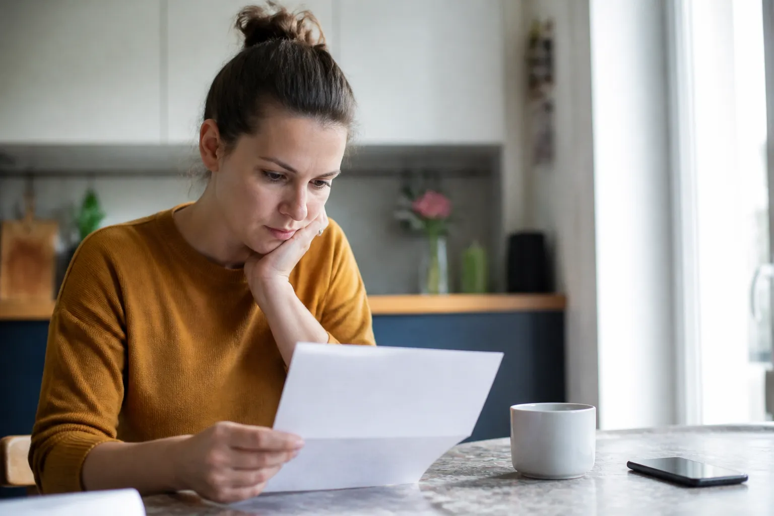 Acheteur lisant un document sur une table de cuisine