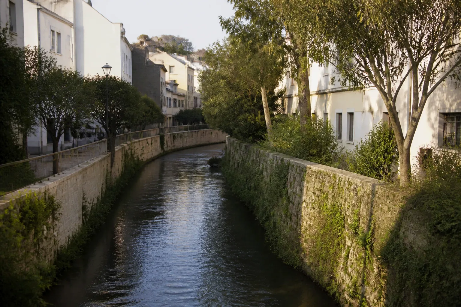 Petite rivière canalisée traversant un quartier urbain