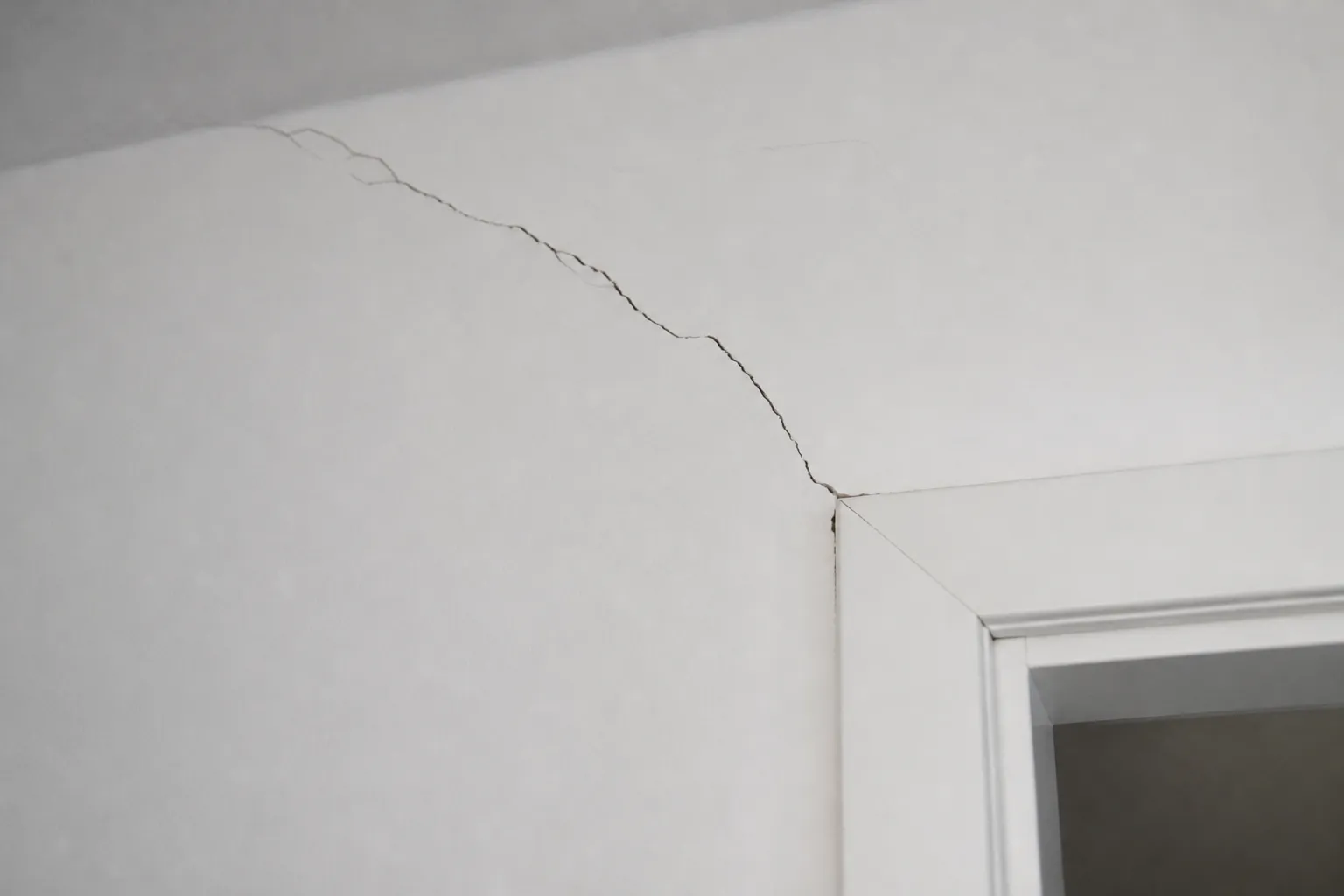 Fissure traversante au-dessus d’une porte intérieure