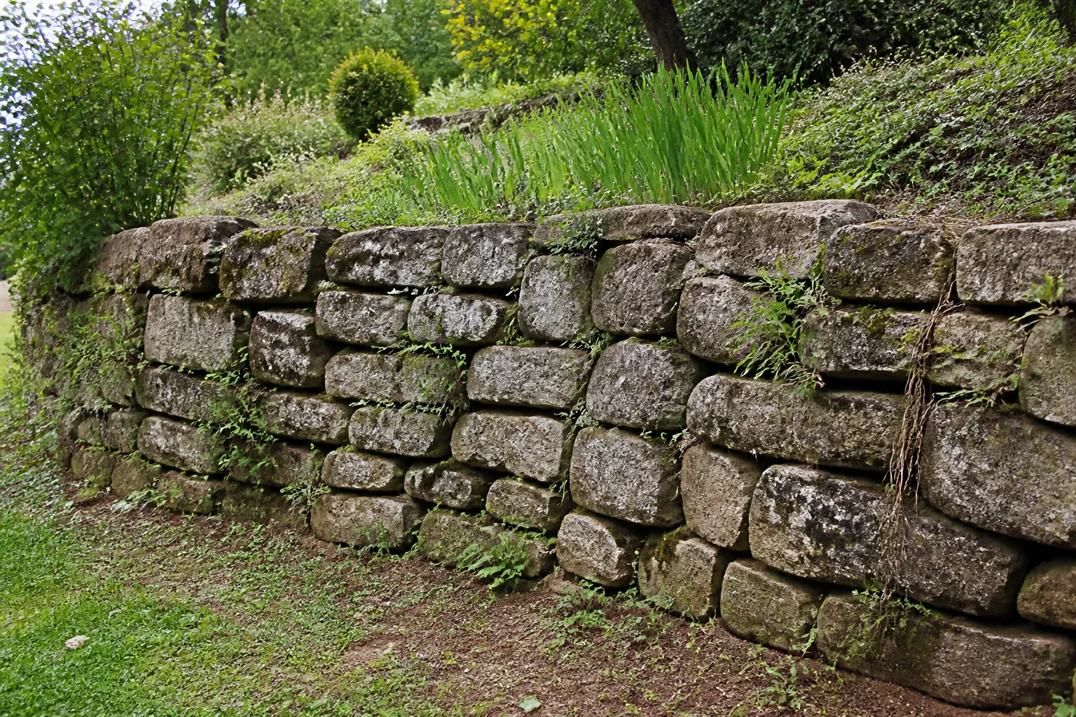 Mur de soutènement en pierre au bord d’un jardin en pente
