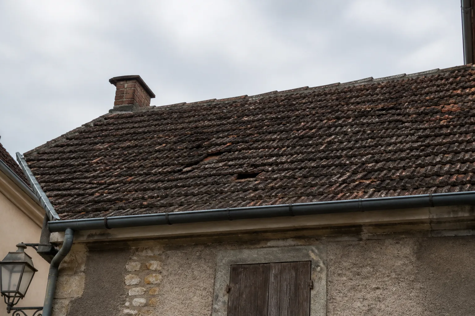Toiture en tuiles vue depuis la rue après une tempête