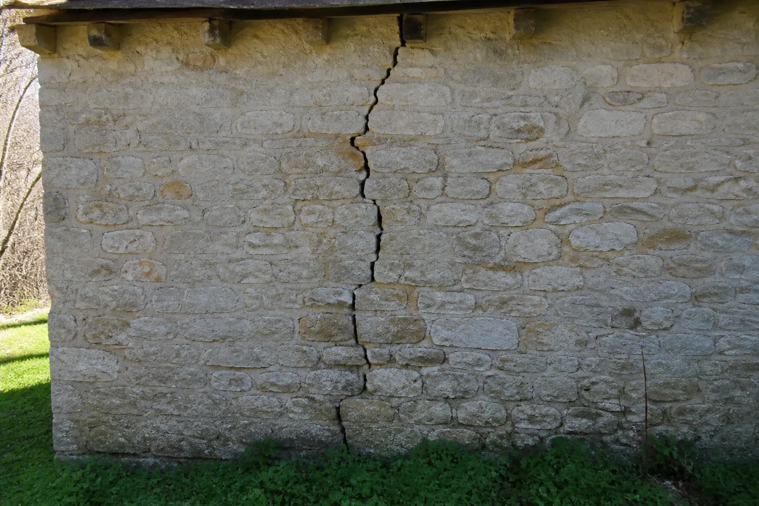 Fissure sur un mur en pierre d’une dépendance rurale
