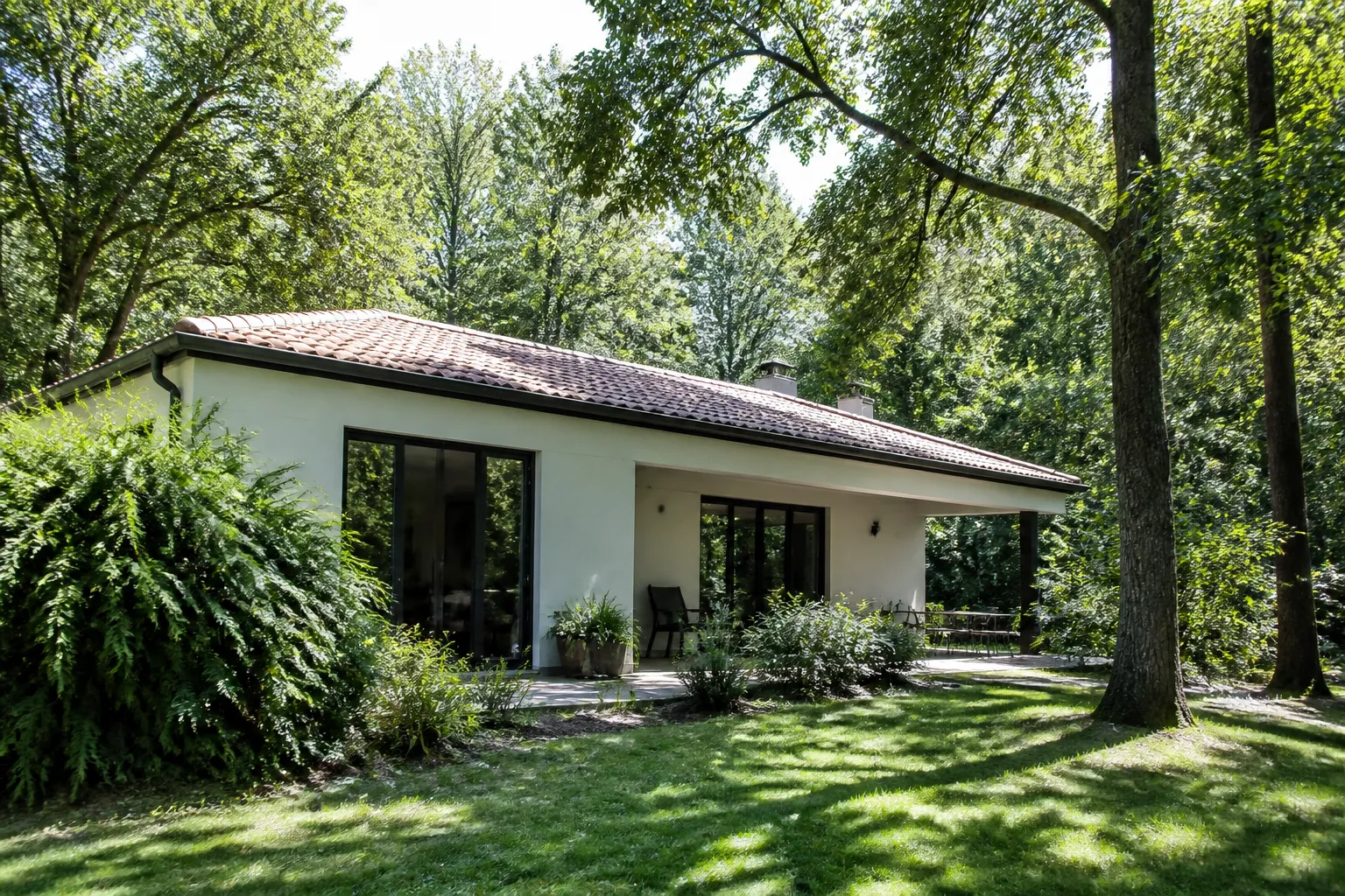 Maison en lisière de bois avec végétation proche du toit