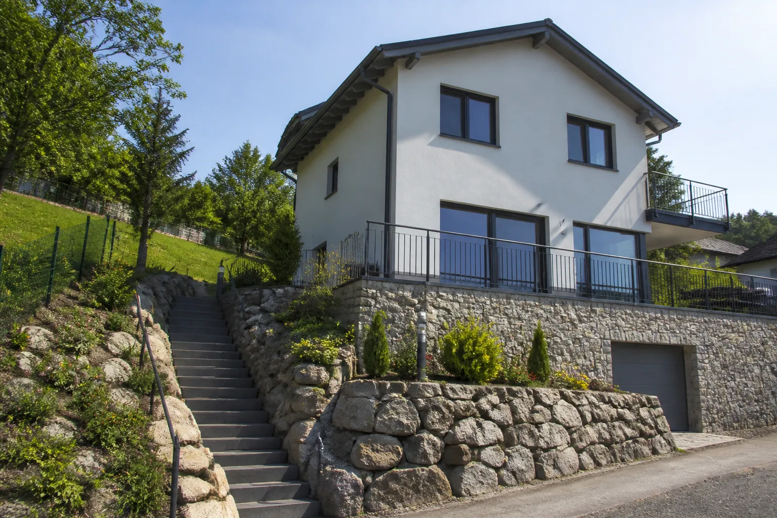 Maison sur un terrain en pente avec mur de soutènement