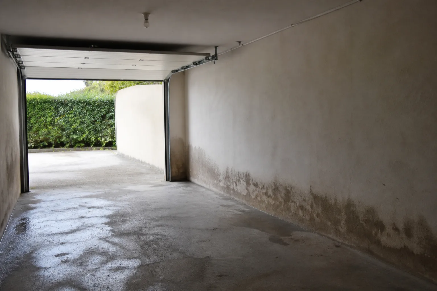 Garage en rez-de-chaussée avec traces d’eau au bas des murs
