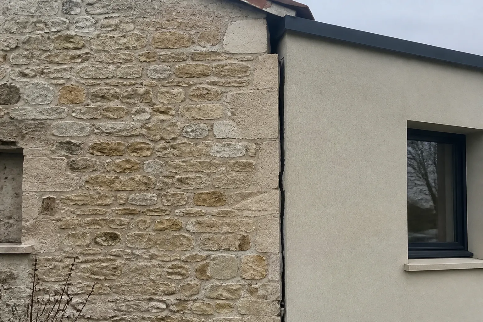 Jonction fissurée entre une maison et une extension