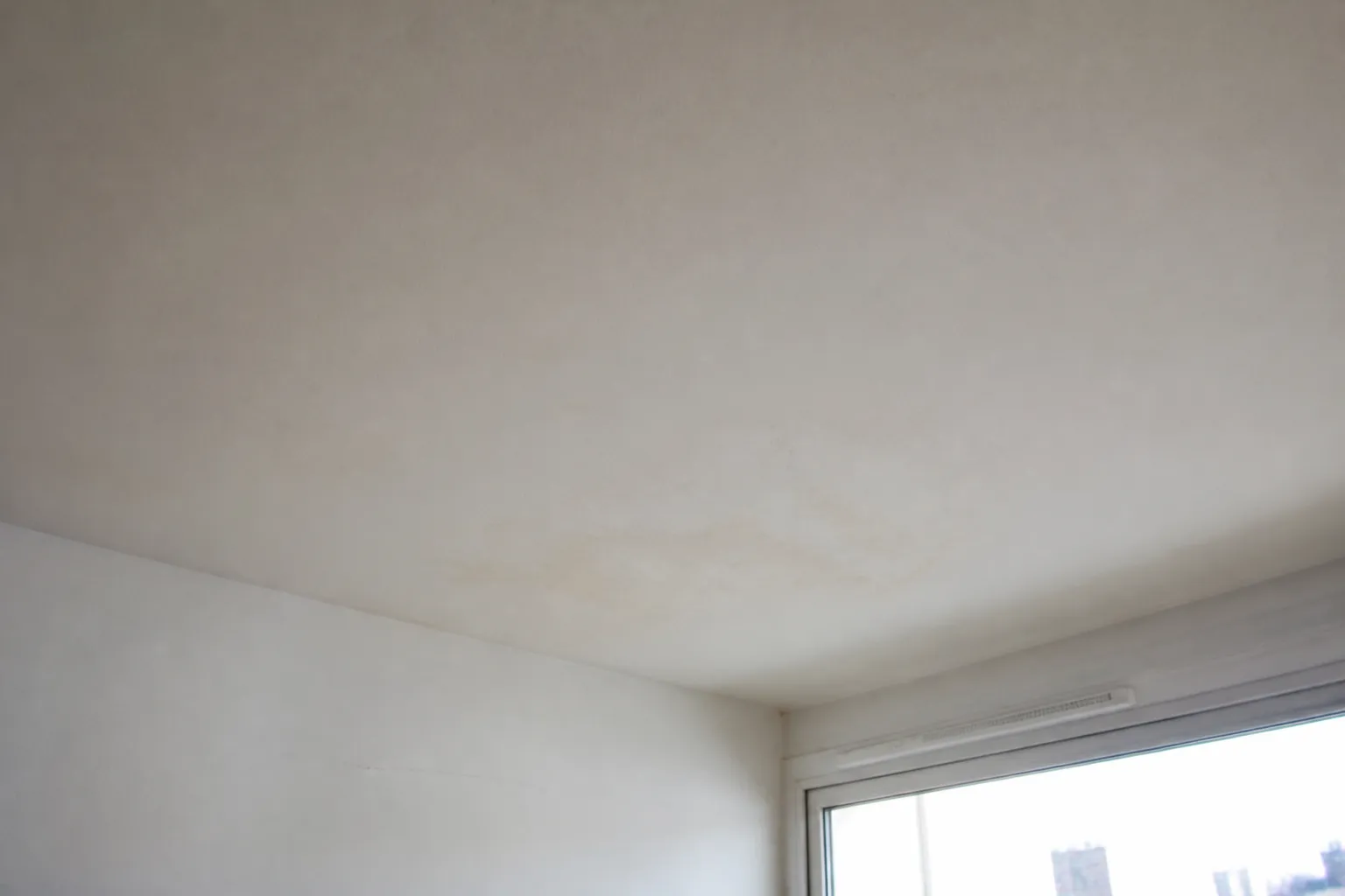Plafond d’un appartement au dernier étage avec une trace d’infiltration