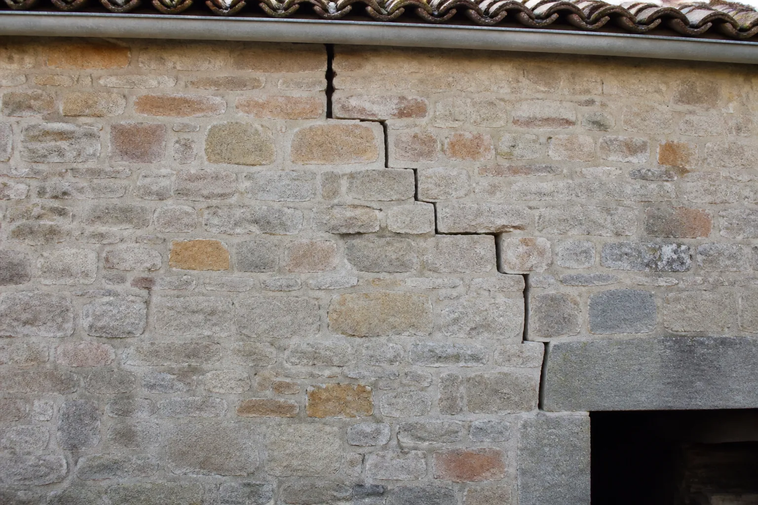 Fissure en escalier sur un mur de maçonnerie de moellons