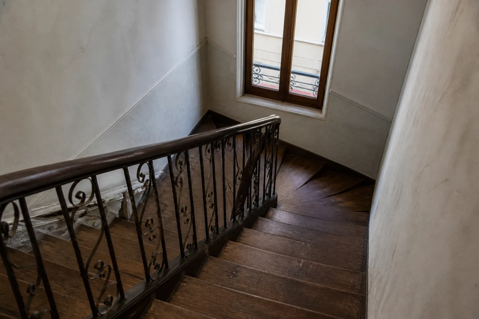 Cage d’escalier d’un immeuble ancien avec marches en bois