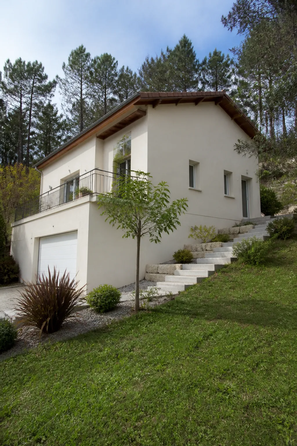 Maison avec sous-sol sur un terrain en pente arboré