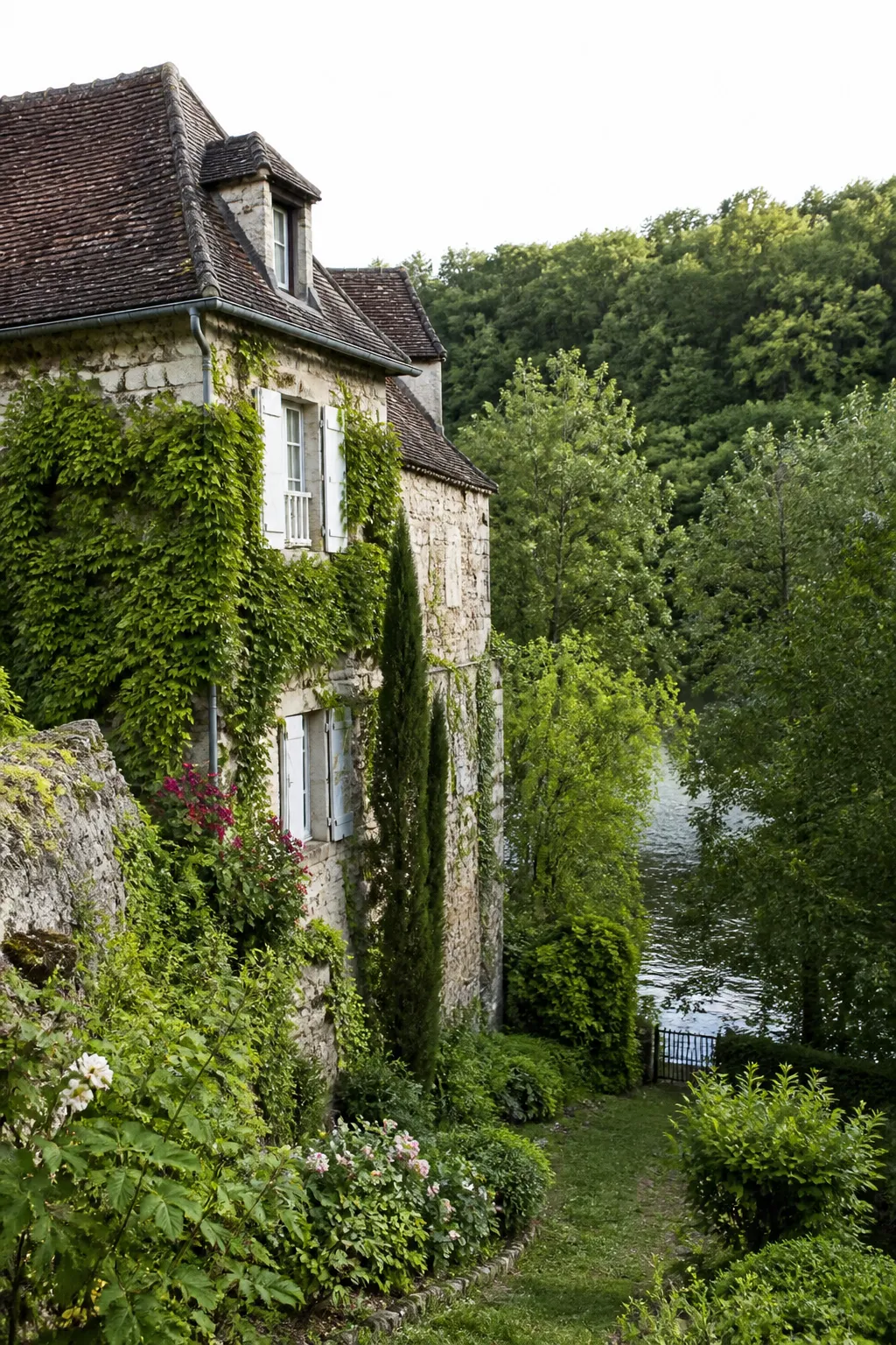 Maison en pierre avec jardin descendant vers une rivière
