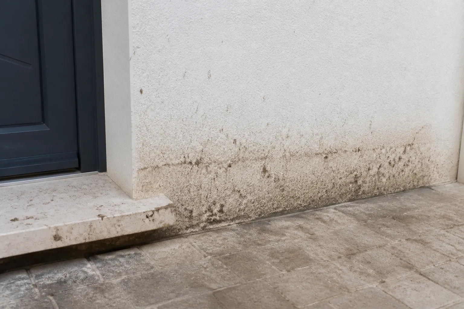 Seuil de porte et bas de mur d’une maison après un épisode pluvieux