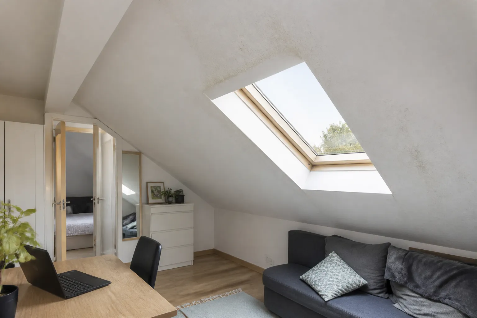 Appartement mansardé avec fenêtre de toit et trace d’humidité