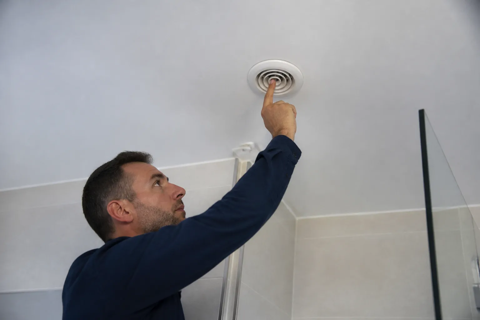 Expert vérifiant une bouche de ventilation dans une salle de bains