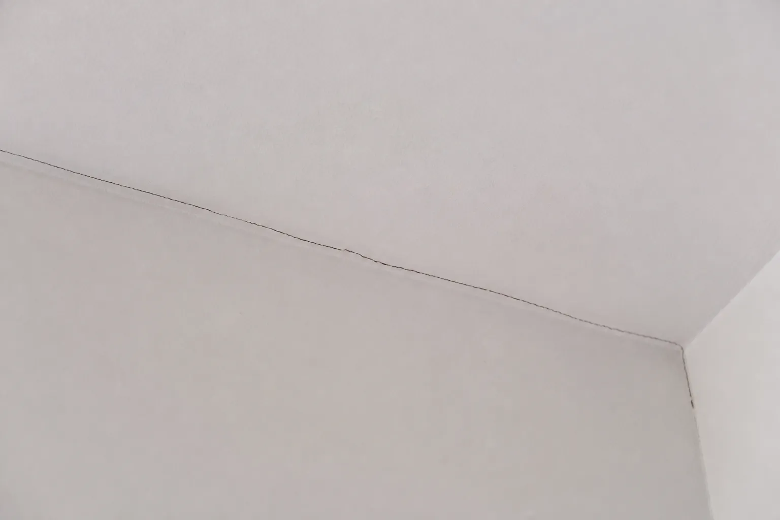 Fissure fine en angle de plafond dans une pièce