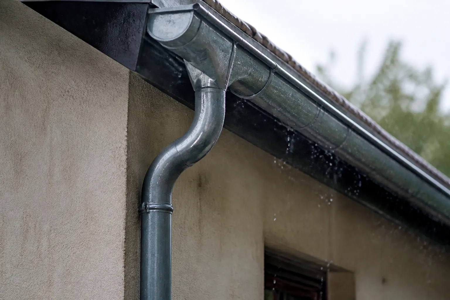 Gouttière et descente d’eau pluviale sur une maison après une averse