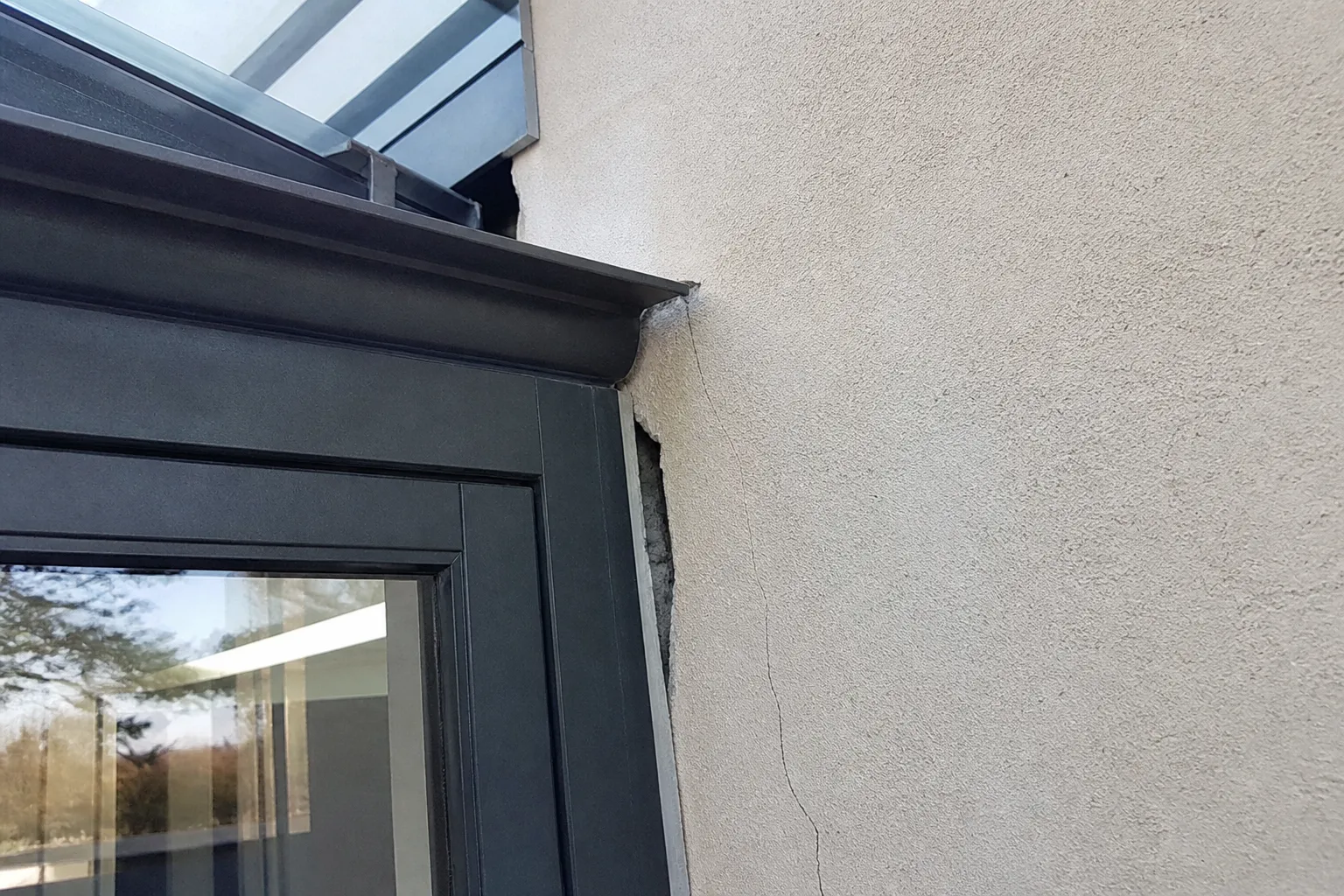 Jonction fissurée entre une véranda et la façade d’une maison