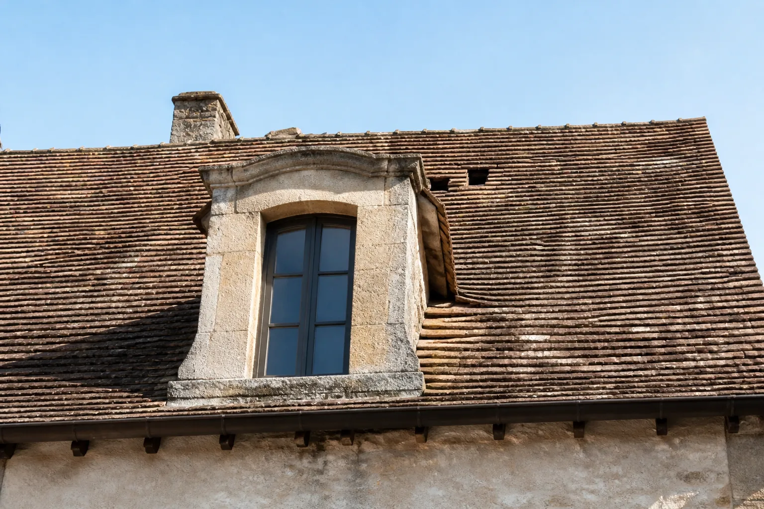 Lucarne et couverture en tuiles observées depuis la rue