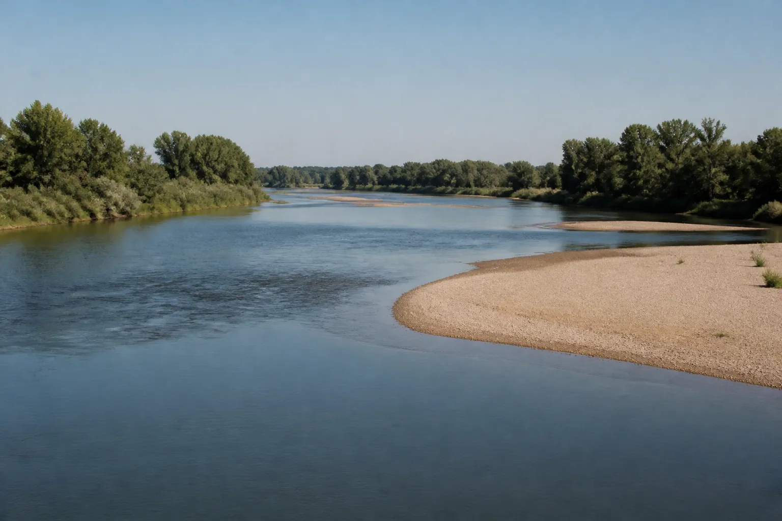 Large rivière bordée de bancs de sable et de végétation