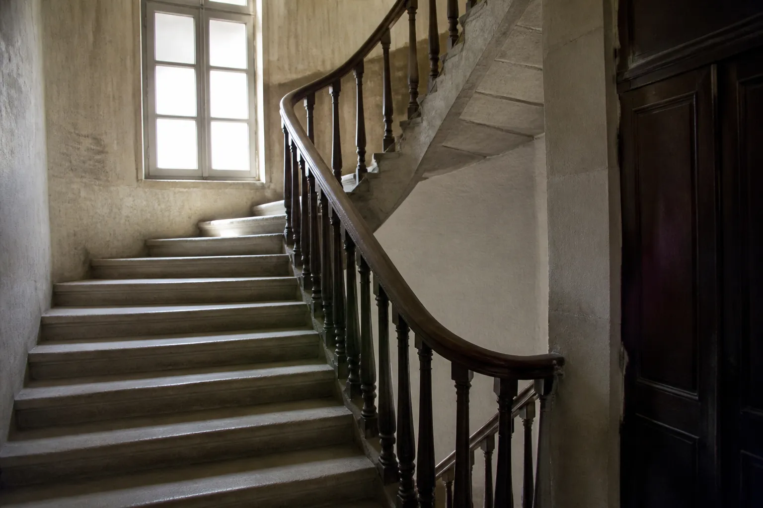 Escalier ancien en pierre et bois dans un immeuble de centre-ville