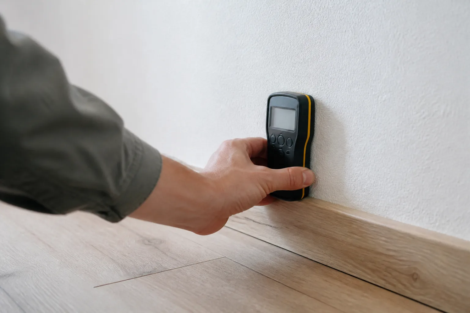 Mesure de l’humidité au pied d’un mur intérieur avec un humidimètre