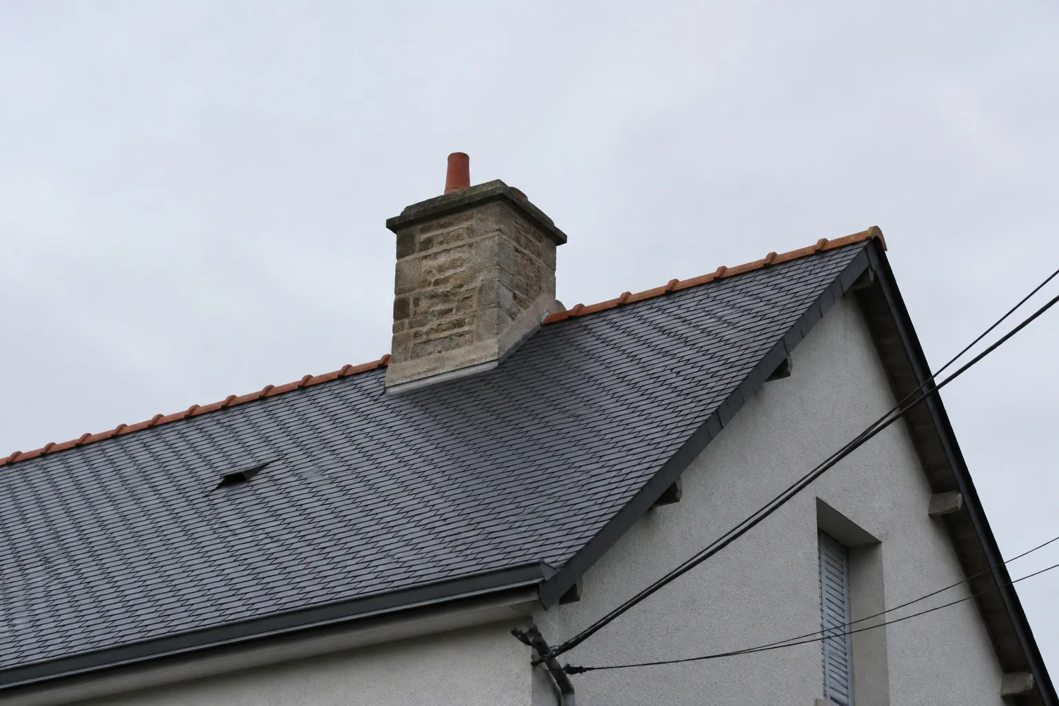 Toiture en ardoise et cheminée vues depuis la rue