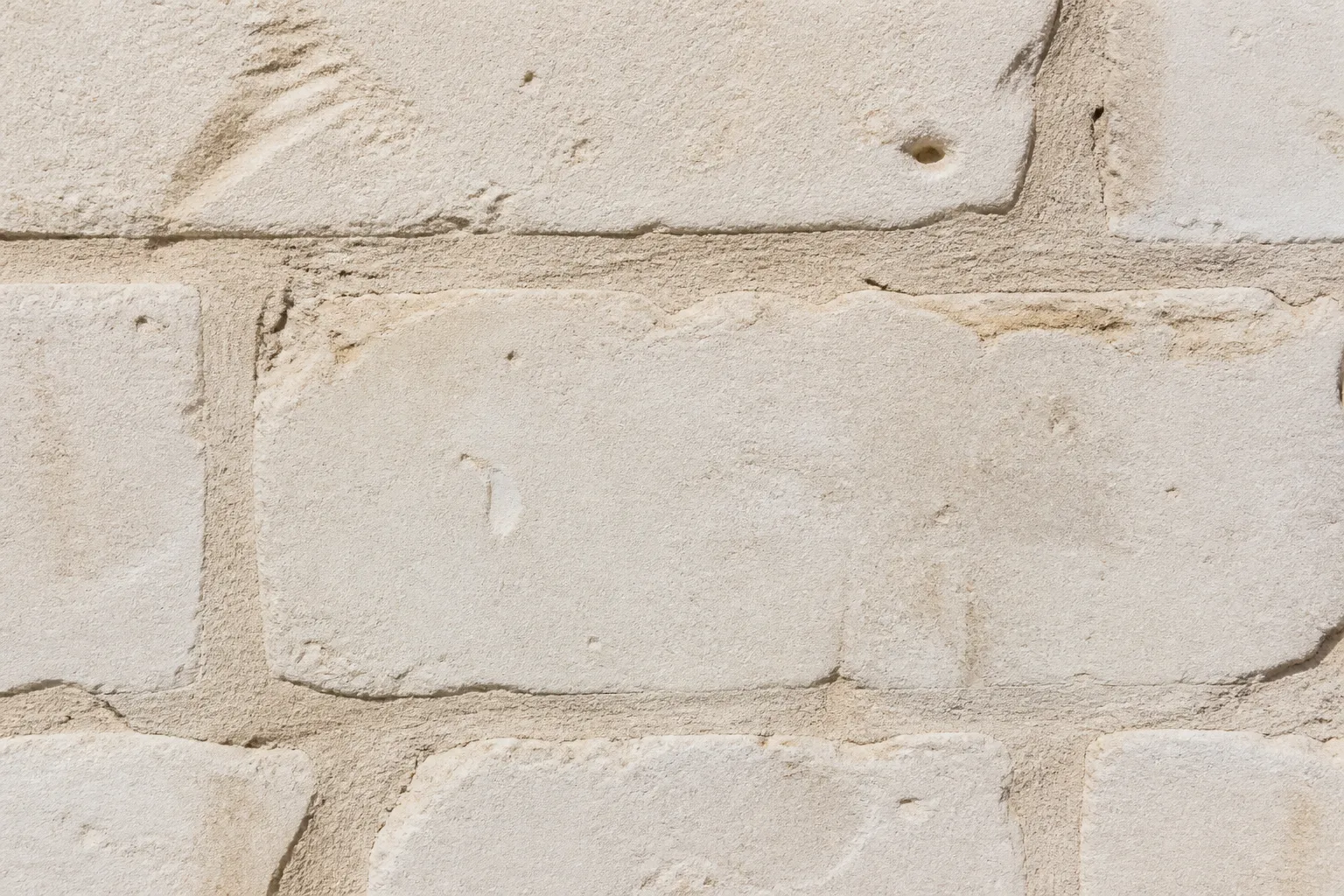Gros plan sur une pierre calcaire de façade avec joints