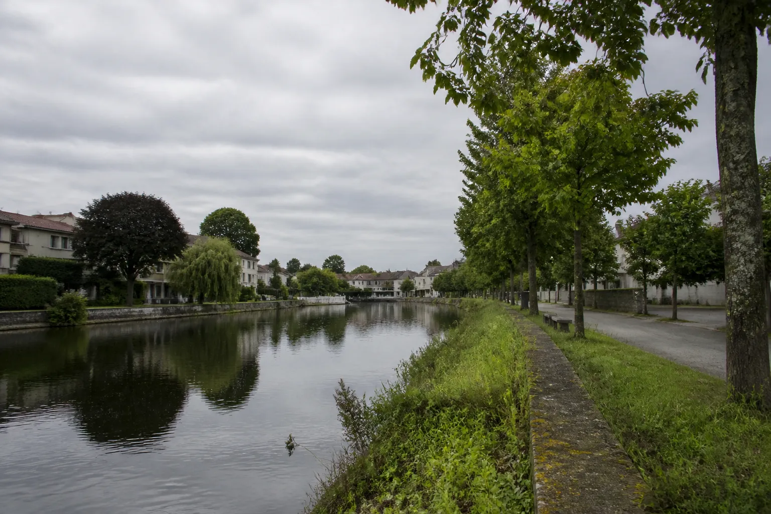 Berge de rivière en zone urbaine bordée de maisons